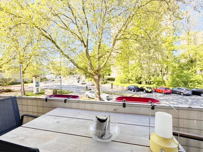 ...und schönem Blick vom Balkon in die von Bäumen gesäumte Straße