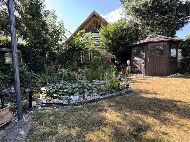 Idyllische Impressionen: Gartenhaus und Teich