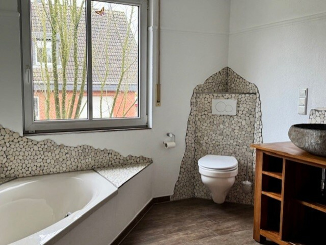 Die sehr geräumige, bodengleiche Dusche mit Glasabtrennung